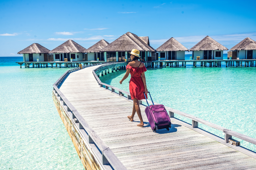 Voyageuse marchant sur un ponton au-dessus d’une mer turquoise