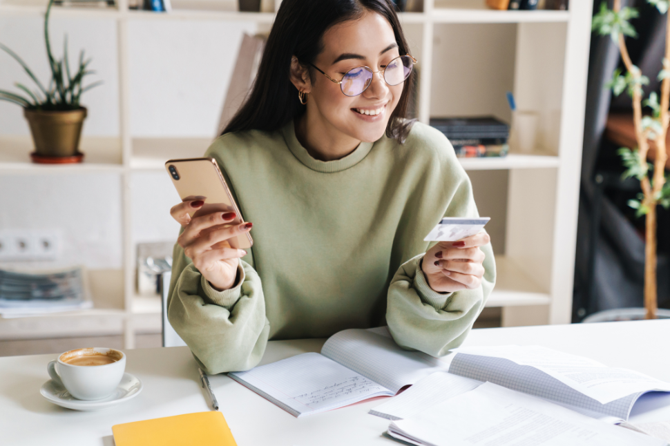 Jeune femme en ligne avec sa banque avant un départ à l’étranger – checklist voyage
